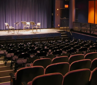 An empty Leonard Nimoy Thalia with chairs and music stands on stage as seen from the back of the theater.